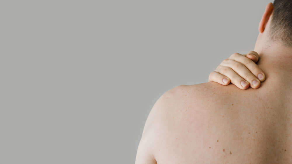 Lipoma de grasa en la espalda tapado con la mano